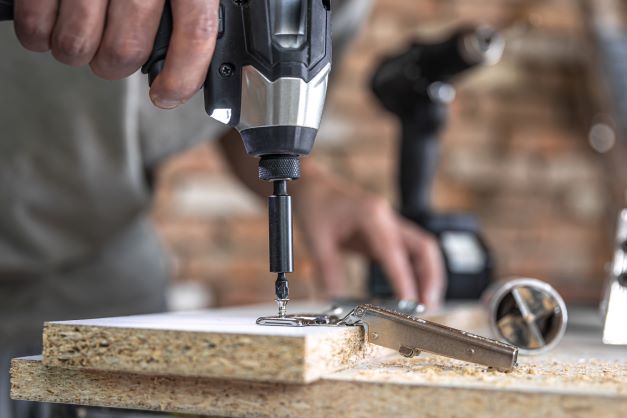 screwingselftappingscrewintometalfasteningholewoodstripusingscrewdriverworkcarpenter Machingo