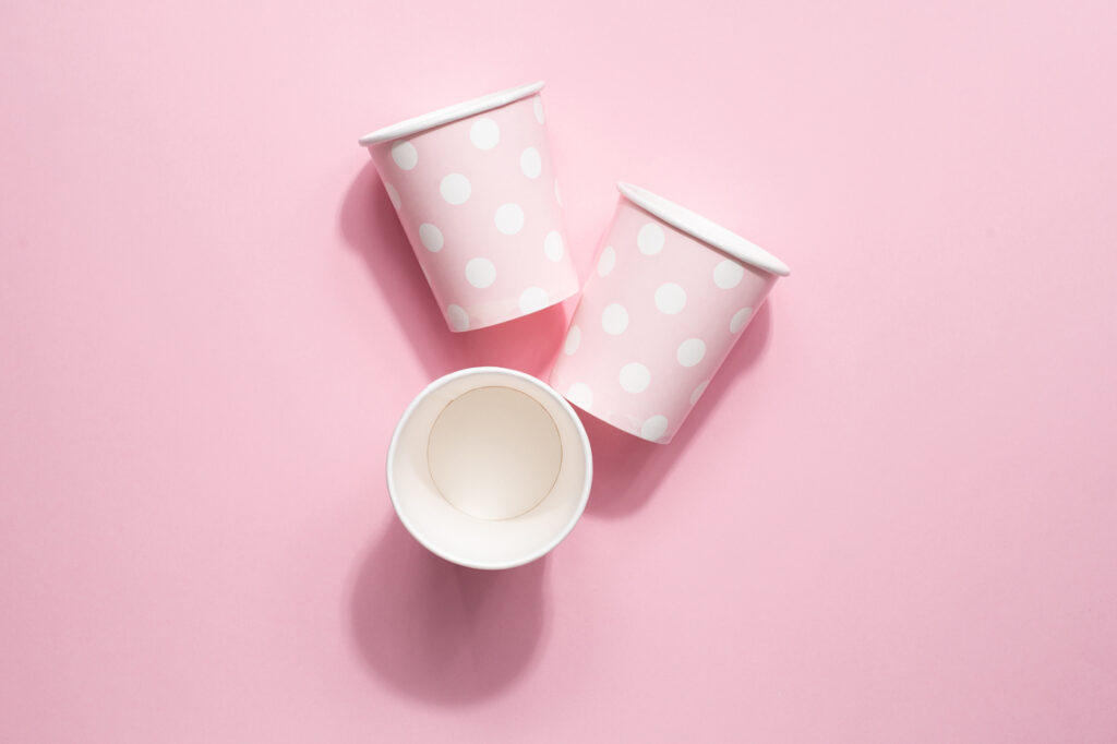 Polka dot disposable paper cups on pink background Machingo
