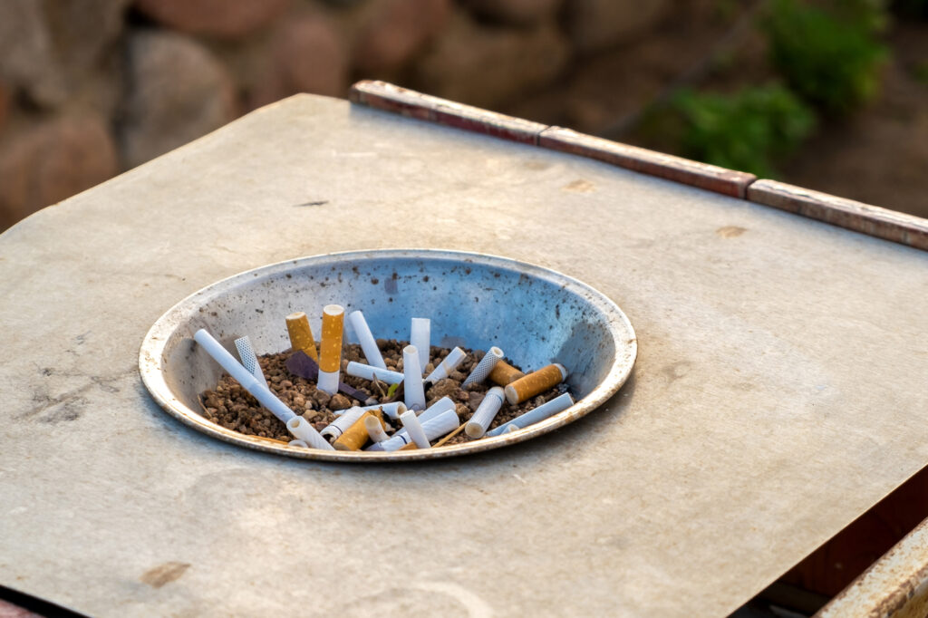 Close up of cigarettes butts in metal ashtray on street Concept of many cigarette debris after smoking Machingo