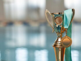 Close-up of a shiny trophy with a teal ribbon, suggesting an award or victory.