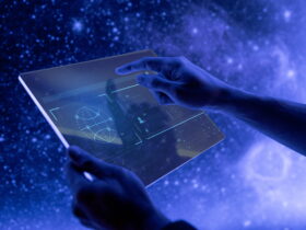 Hands holding a tablet with a glowing holographic interface against a blue, starry background.