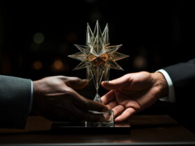 Transparent glass star trophy being handed between two people in suits against a dark background.