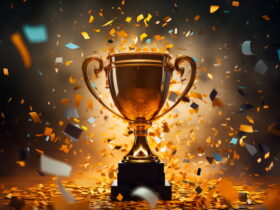 Golden trophy on a pedestal with orange and teal confetti falling around it.