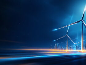 Nighttime city skyline with glowing wind turbines and blue light trails in the foreground.