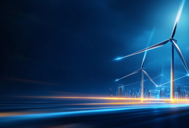 Nighttime city skyline with glowing wind turbines and blue light trails in the foreground.